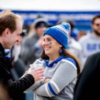 Two alumni smile and chat during the tailgate